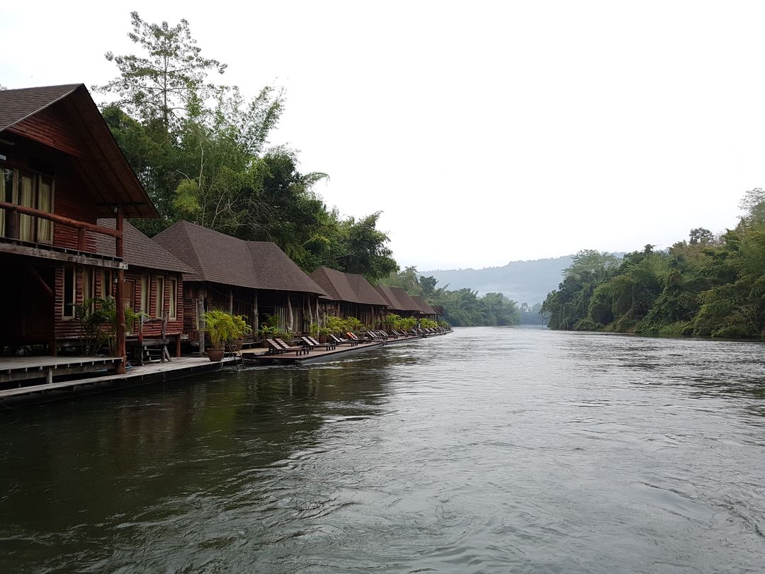 Riverside Wooden Cabins Surrounded by Lush Greenery and Tranquil Water - Free Images, Stock Photos and Pictures on Pikwizard.com