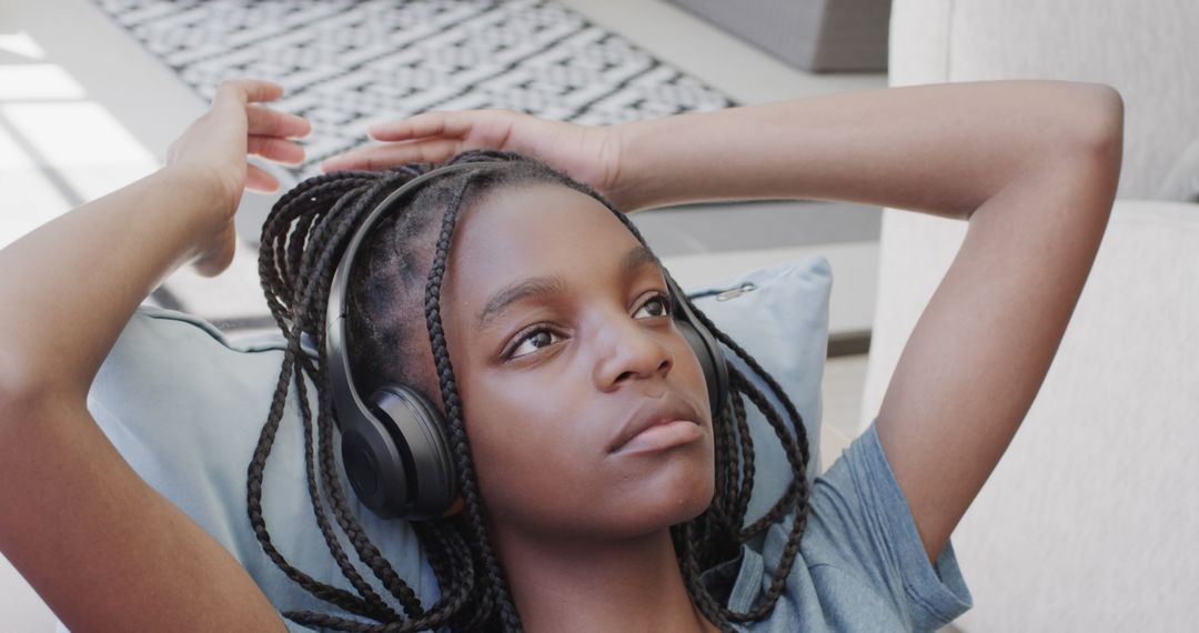 Young African American Girl Relaxing at Home with Headphones - Free Images, Stock Photos and Pictures on Pikwizard.com