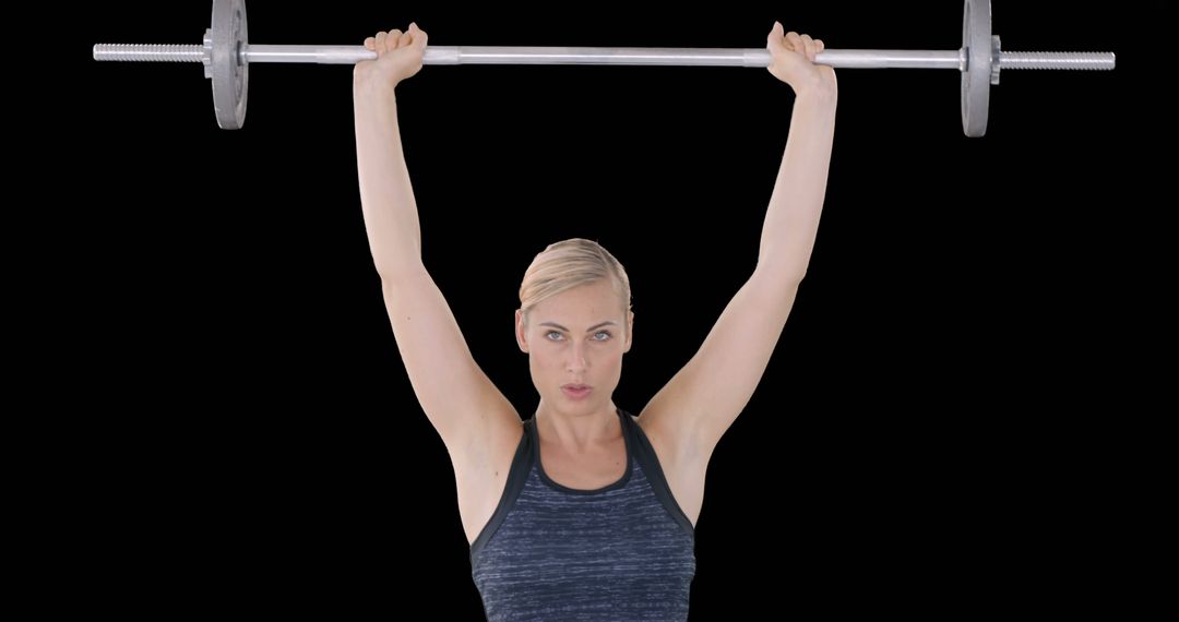 Strong Woman Lifting Barbell Overhead Against Black Background - Free Images, Stock Photos and Pictures on Pikwizard.com