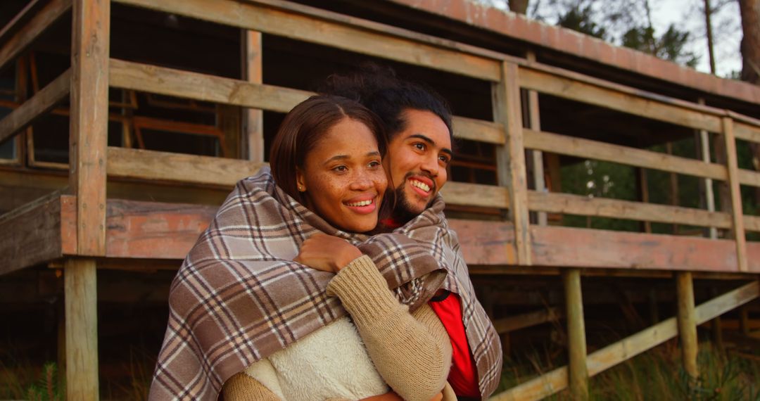 Couple Embracing Outdoors in Warm Blanket by Rustic Cabin - Free Images, Stock Photos and Pictures on Pikwizard.com