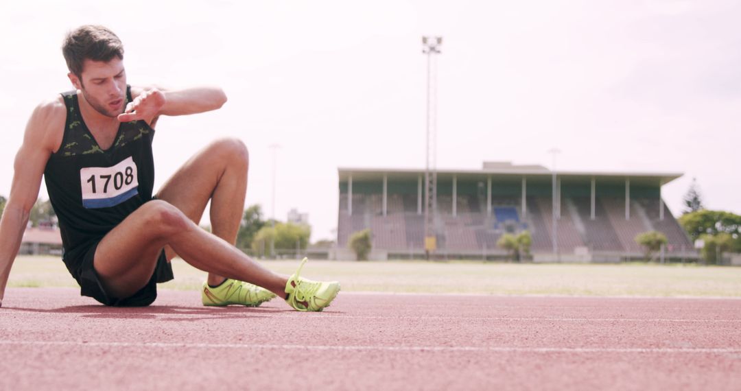 Exhausted runner sitting on track after race - Free Images, Stock Photos and Pictures on Pikwizard.com