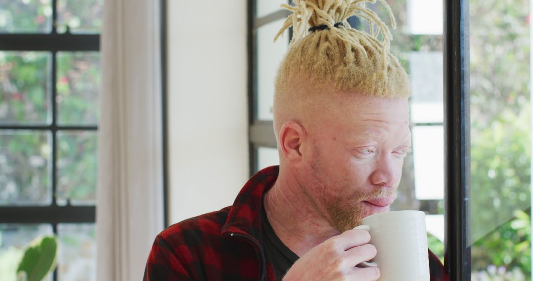 Albino Man with Dreadlocks Drinking Coffee by Sunny Window - Free Images, Stock Photos and Pictures on Pikwizard.com