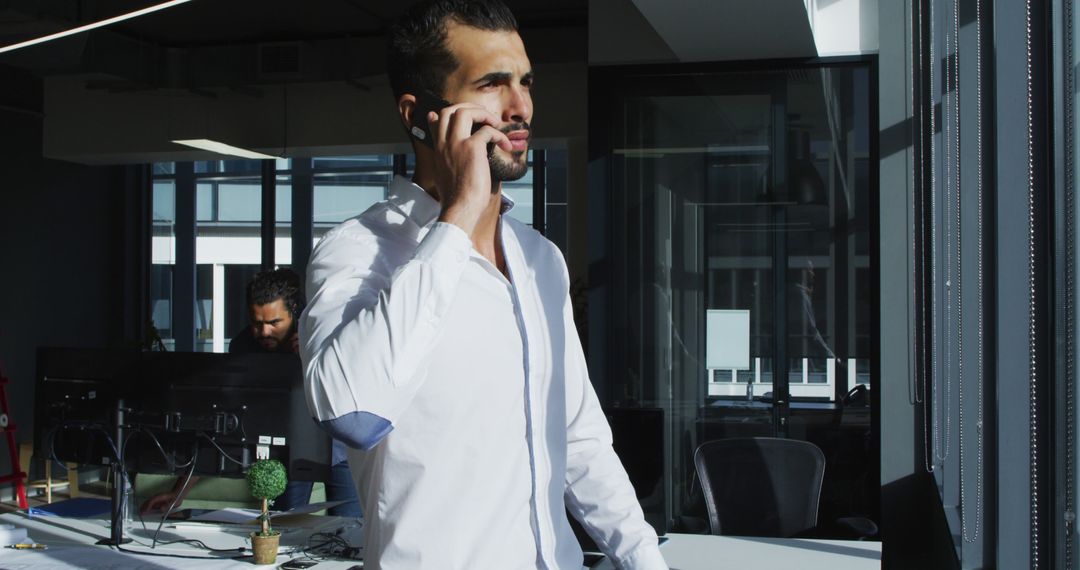 Businessman Talking on Smartphone in Modern Office - Free Images, Stock Photos and Pictures on Pikwizard.com