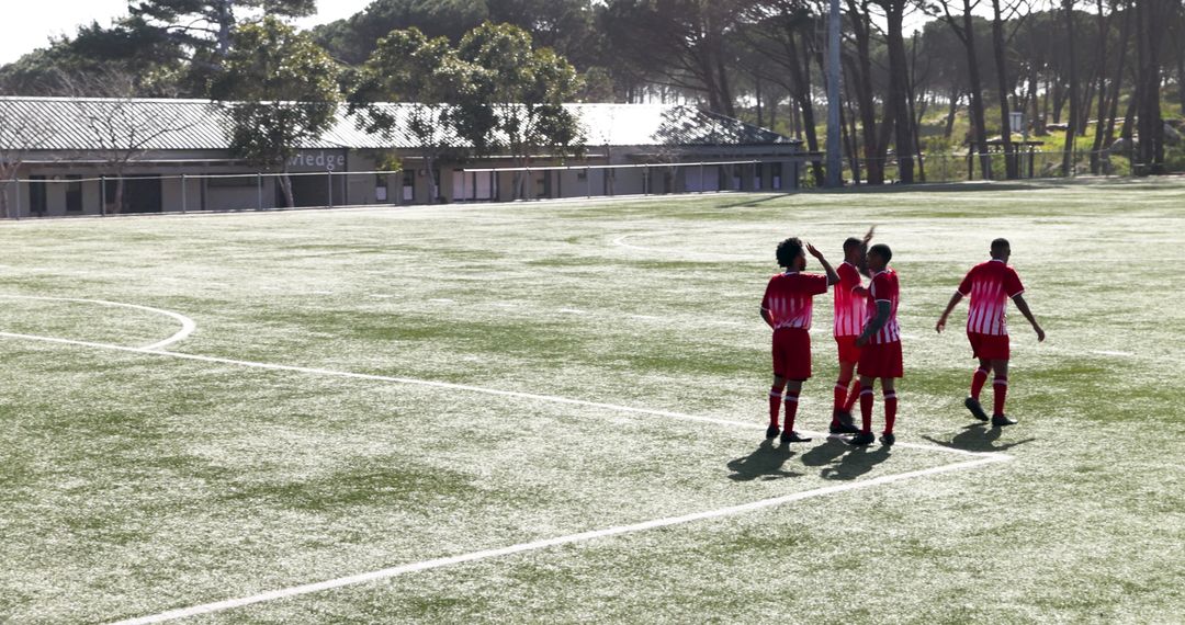 Youth Soccer Players Celebrating on Field in Team Jerseys