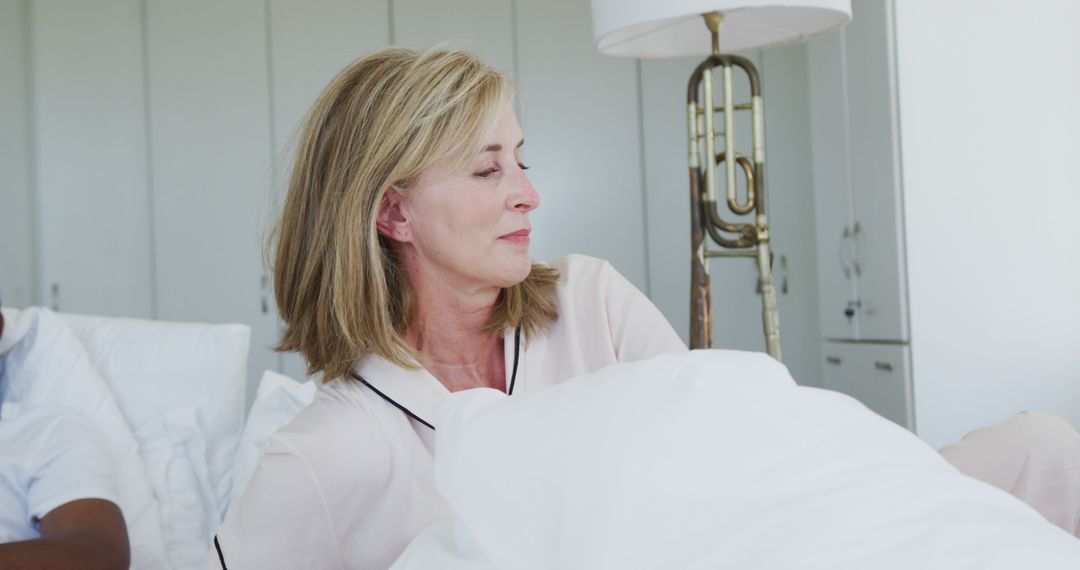 Sad Middle Aged Woman Sitting in Bed Looking Away - Free Images, Stock Photos and Pictures on Pikwizard.com