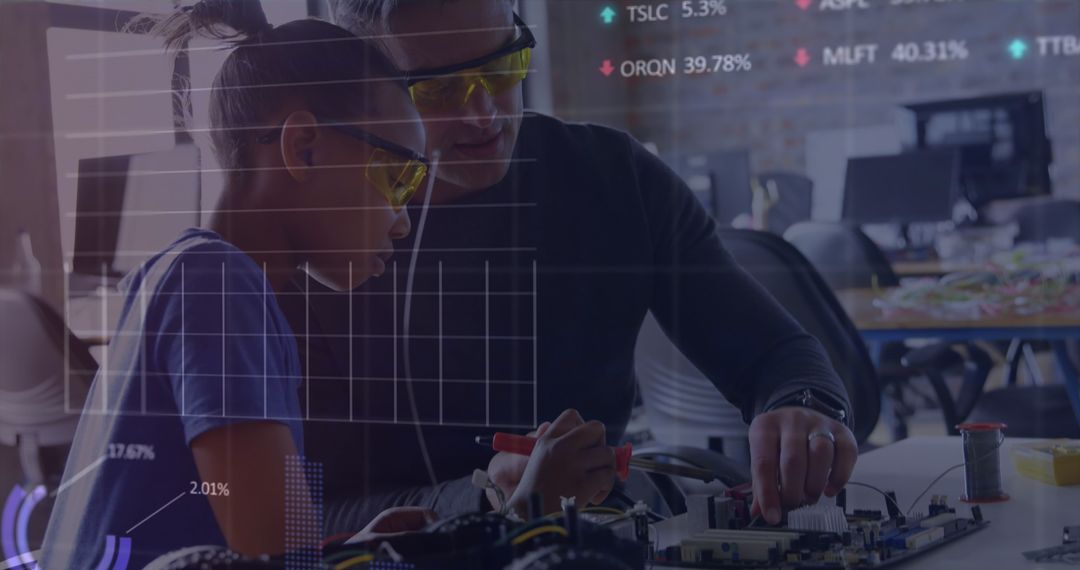 Mentor Teaching Young Apprentice Electronics in Modern Workshop