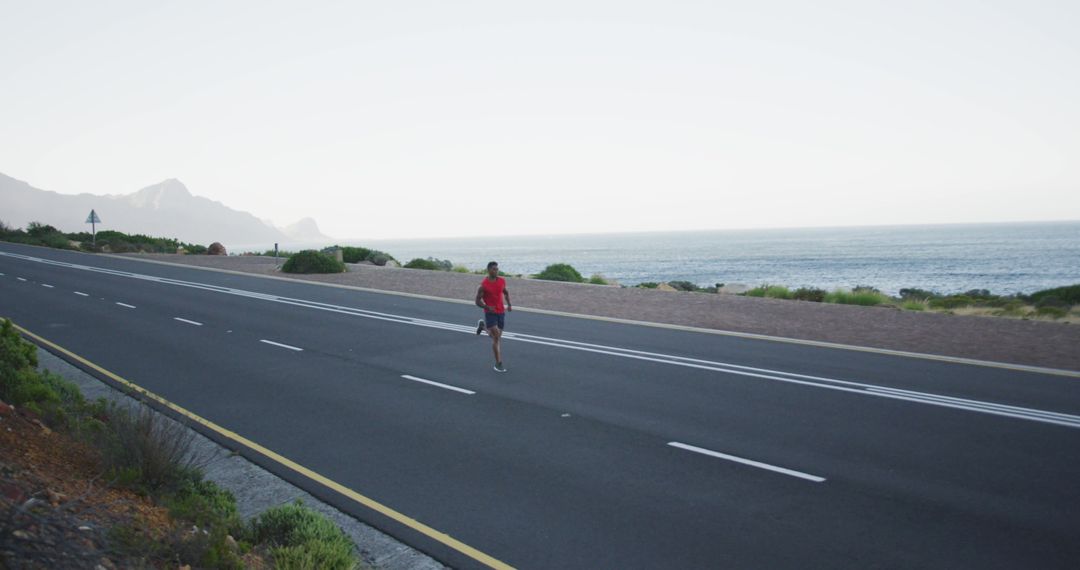 Athlete Jogging on Coastal Road with Ocean View - Free Images, Stock Photos and Pictures on Pikwizard.com
