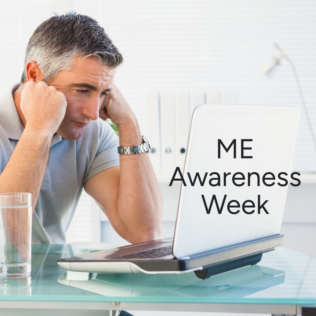Worried Caucasian Man at Desk with Laptop for ME Awareness Week