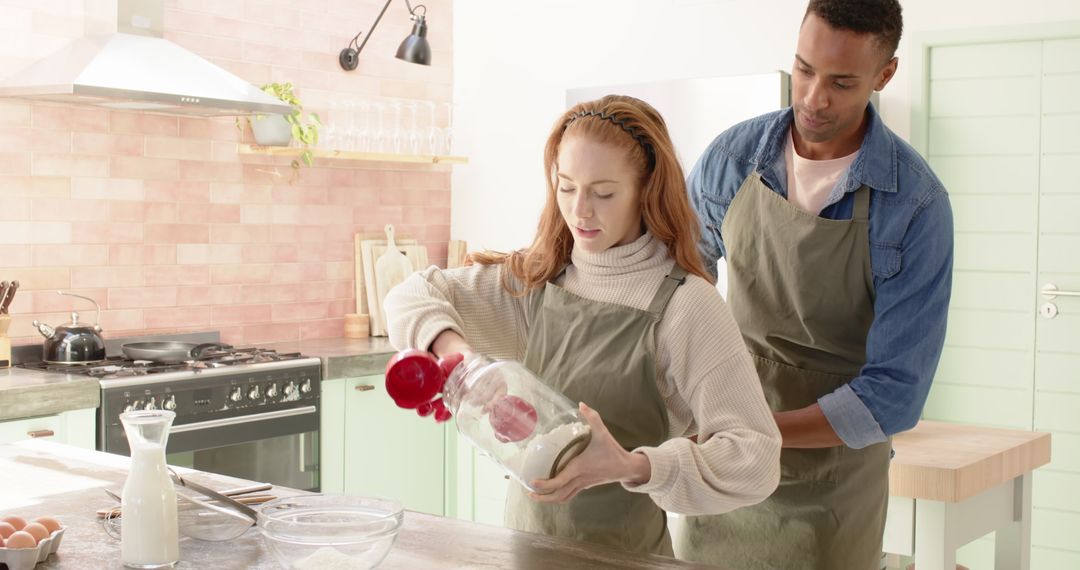 Diverse Couple Baking Together in Bright Kitchen Using Aprons