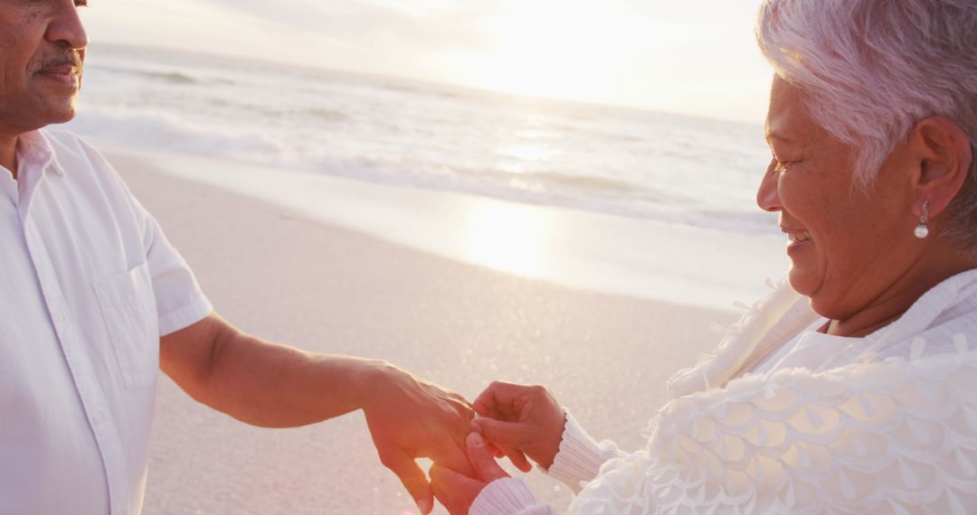 Senior Couple Exchanging Rings at Sunset Beach Setting