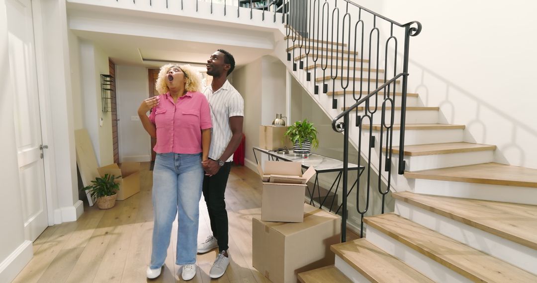 Couple Joyfully Settling into New Home with Boxes Lay Around