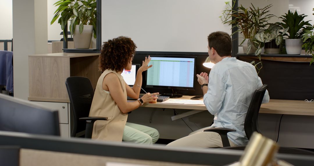 Colleagues Collaborating on Spreadsheet in Contemporary Office Environment