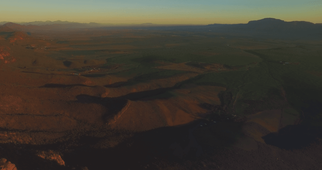 Aerial View of Vast Landscape with Setting Sun Shadows and Transparent Hues