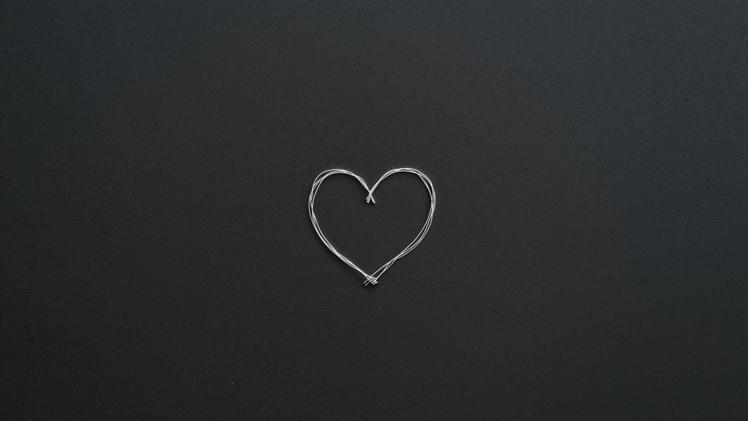 Silver Wire Heart Shape on Matte Black Surface Top View