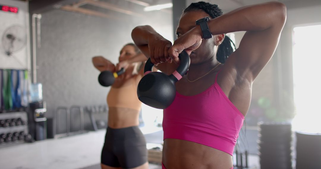 Women Building Strength with Kettlebells in Gym
