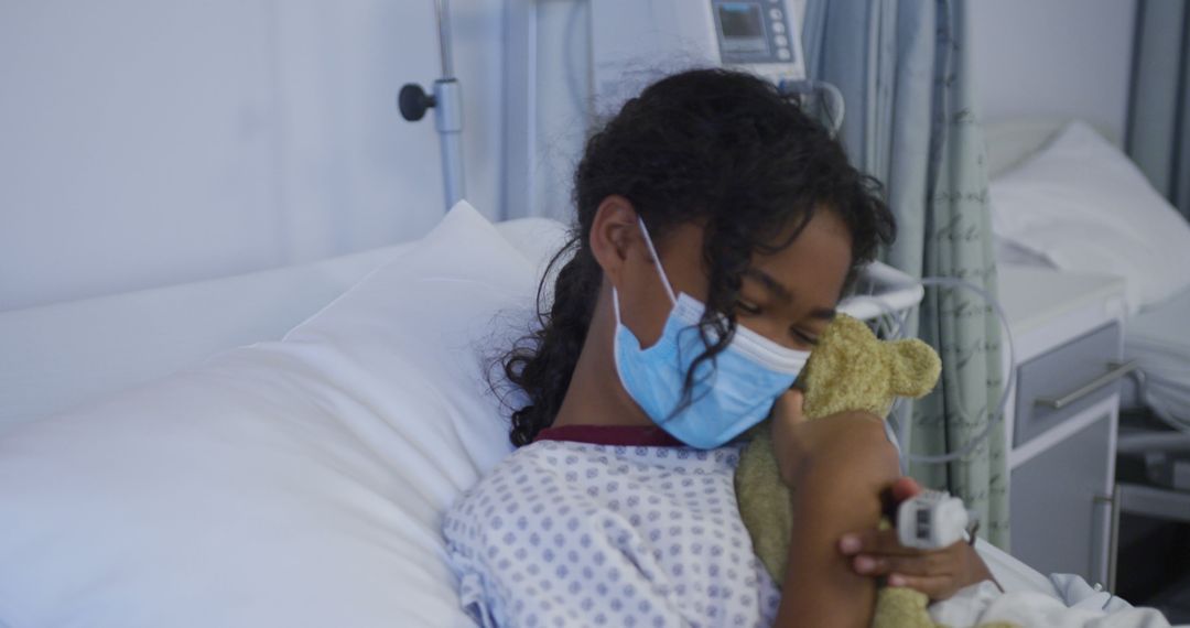 Young Girl Hugging Teddy Bear in Hospital Bed Wearing Medical Mask - Free Images, Stock Photos and Pictures on Pikwizard.com