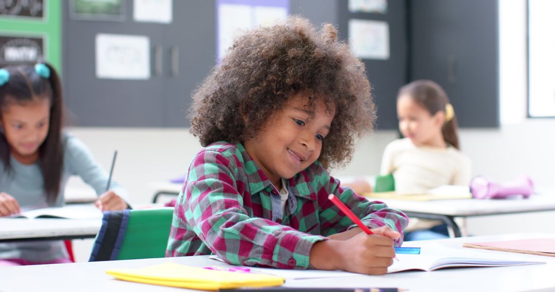 Child Writing in Classroom Focusing on Schoolwork