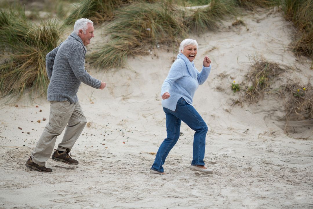 Senior Couple Enjoying Fun at Beach - Free Images, Stock Photos and Pictures on Pikwizard.com