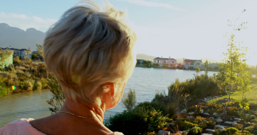 Senior Woman Enjoying Sunrise by Tranquil Lakeside - Free Images, Stock Photos and Pictures on Pikwizard.com