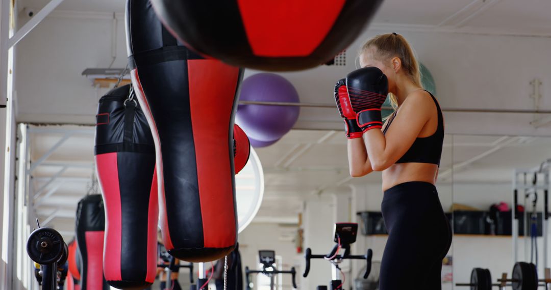 Woman Training in Gym with Punching Bag - Free Images, Stock Photos and Pictures on Pikwizard.com