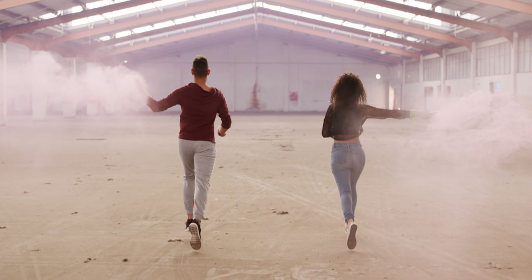 Couple Running in Abandoned Warehouse with Smoke Bombs - Free Images, Stock Photos and Pictures on Pikwizard.com