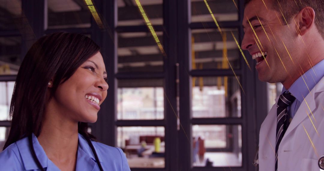 Smiling nurse and doctor collaborating and laughing in modern clinical corridor