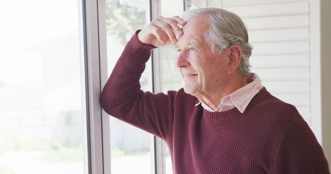 Elderly Man Looking Thoughtfully Out Window with Hand on Forehead - Free Images, Stock Photos and Pictures on Pikwizard.com