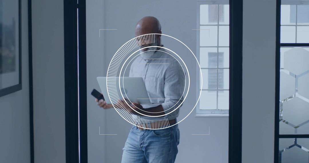 Professional Man Handling Laptop and Smartphone in Modern Office