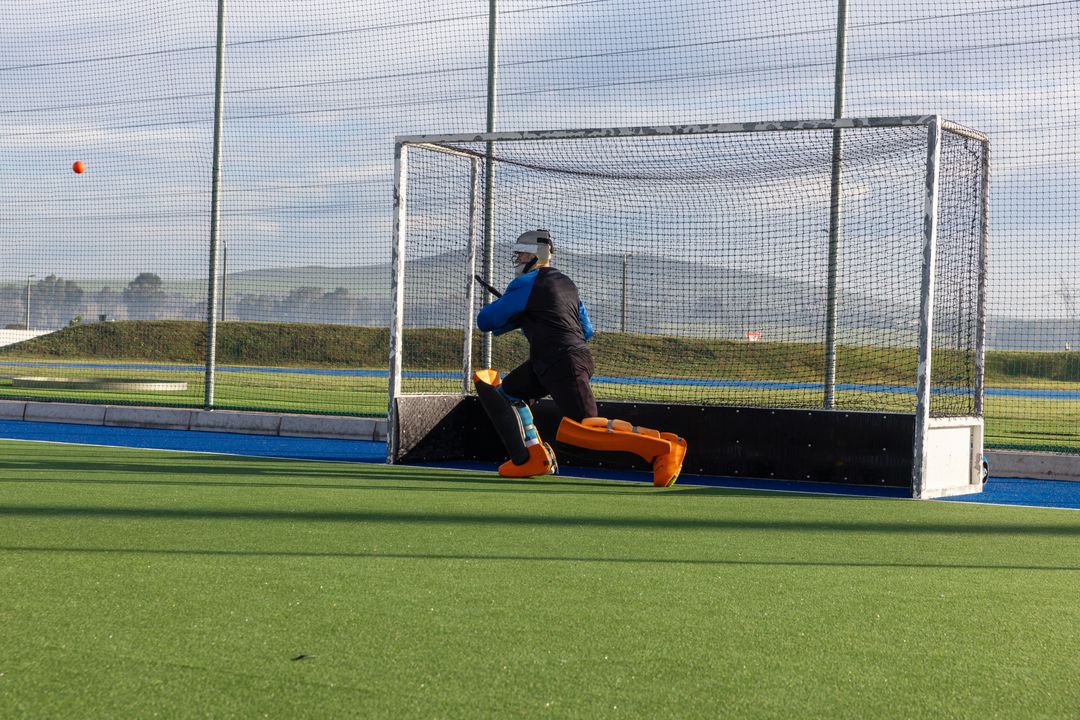 Field Hockey Goalkeeper Blocking Ball in Intense Game