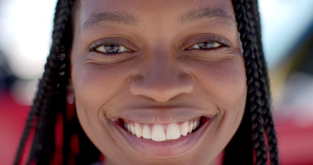 Beaming Smile of Young Woman with Braided Hair Highlighting Happiness