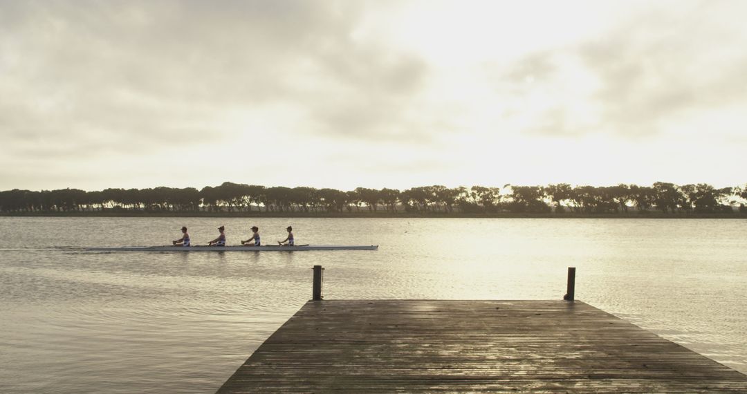 Four Athletes Rowing in Synchrony on Tranquil River at Sunrise - Free Images, Stock Photos and Pictures on Pikwizard.com