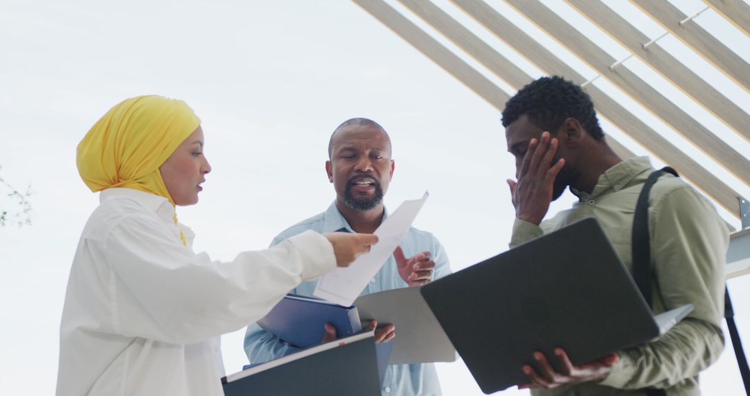 Diverse Business Team Collaborating Outdoors on Project