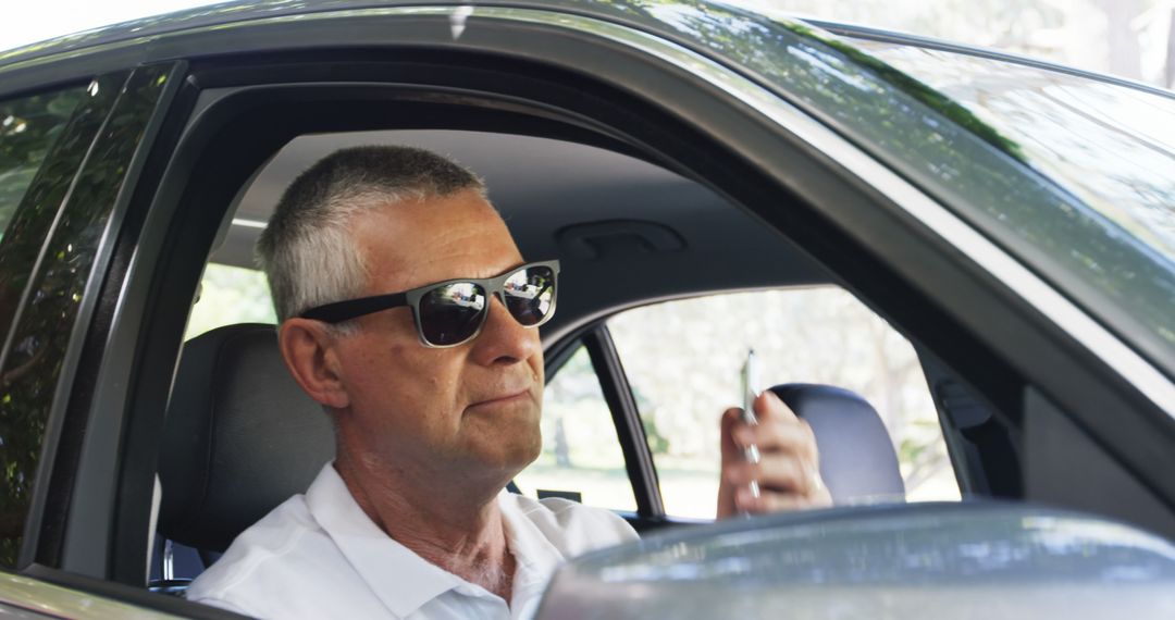 Mature Man in Car Wearing Sunglasses with Smartphone - Free Images, Stock Photos and Pictures on Pikwizard.com