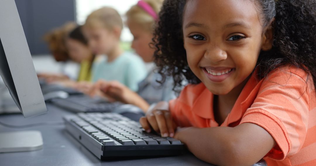 Smiling African American Girl Using Computer in Classroom