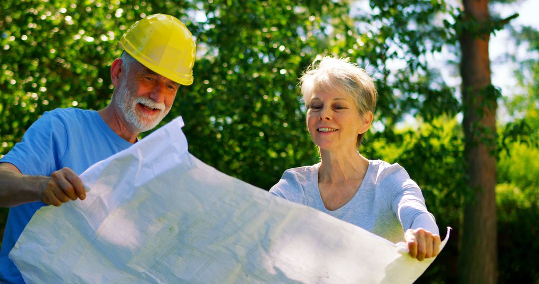 Senior Engineer and Woman Examining Blueprints Outdoors - Free Images, Stock Photos and Pictures on Pikwizard.com