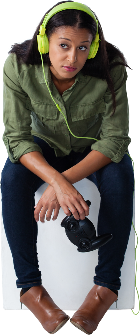 Biracial woman listening to music with green headphones, holding video game controller, transparent - Download Free Stock Images Pikwizard.com