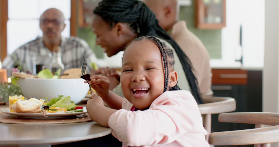 Laughing Child Enjoying Family Meal at Home - Free Images, Stock Photos and Pictures on Pikwizard.com