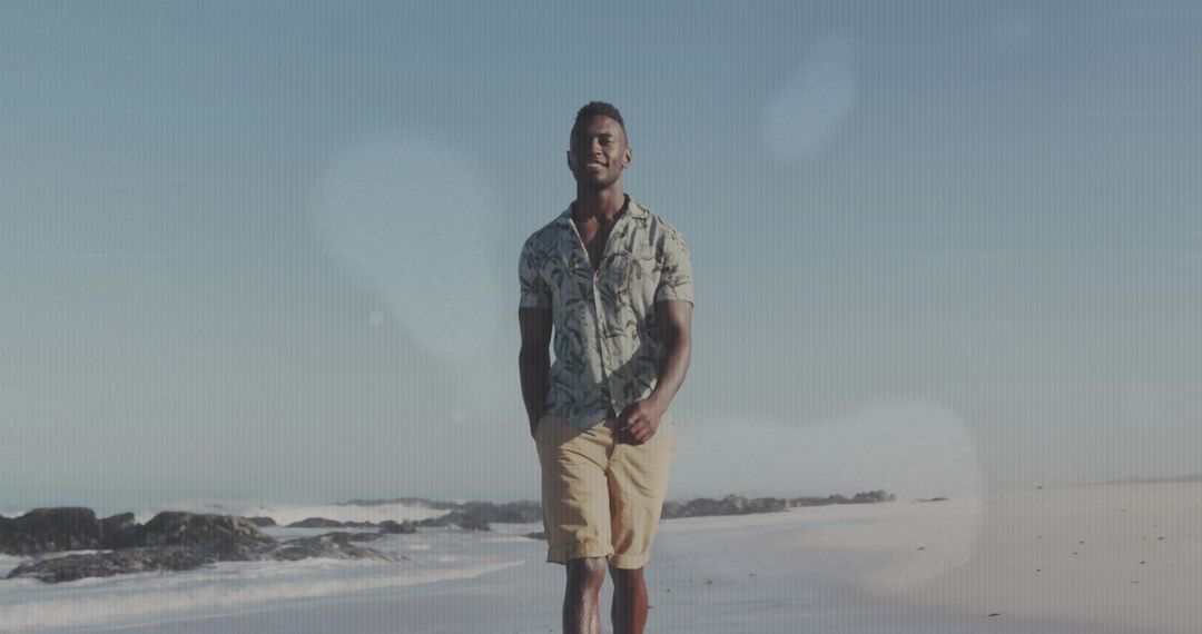 Man Walking by Ocean in Casual Outfit on Sunny Beach Day