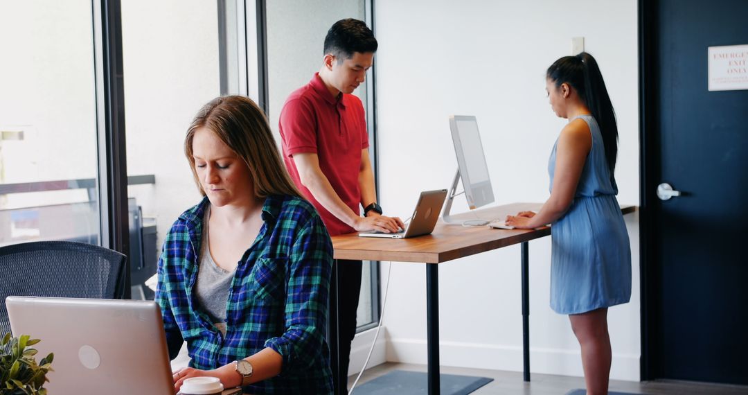 Diverse Colleagues Focused on Varied Computing Tasks in Modern Office
