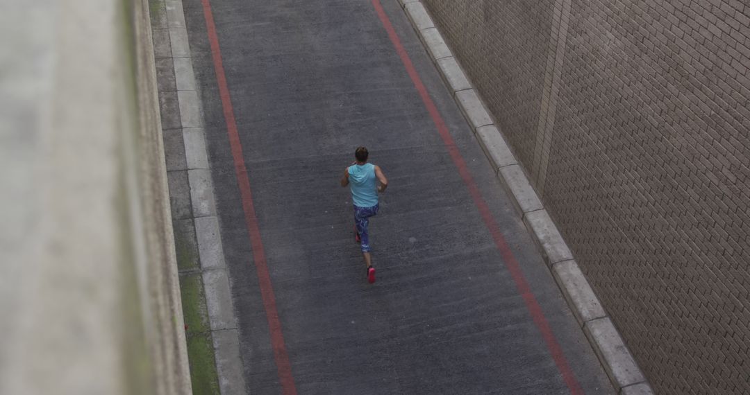 Man Running on Urban Road Surrounded by Brick Walls - Free Images, Stock Photos and Pictures on Pikwizard.com