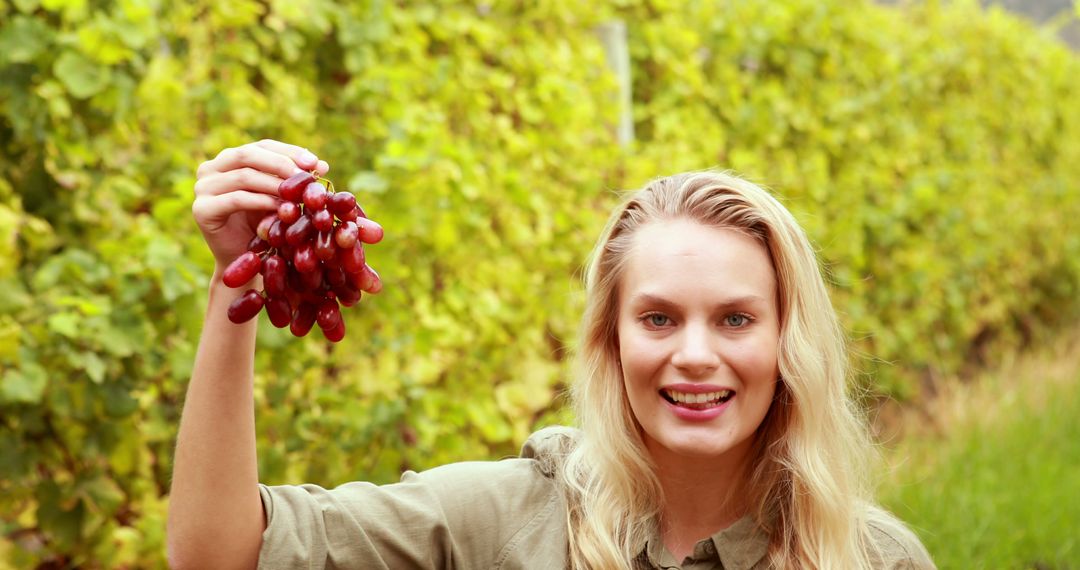 Smiling Woman Holding Bunch of Grapes in Vineyard - Free Images, Stock Photos and Pictures on Pikwizard.com