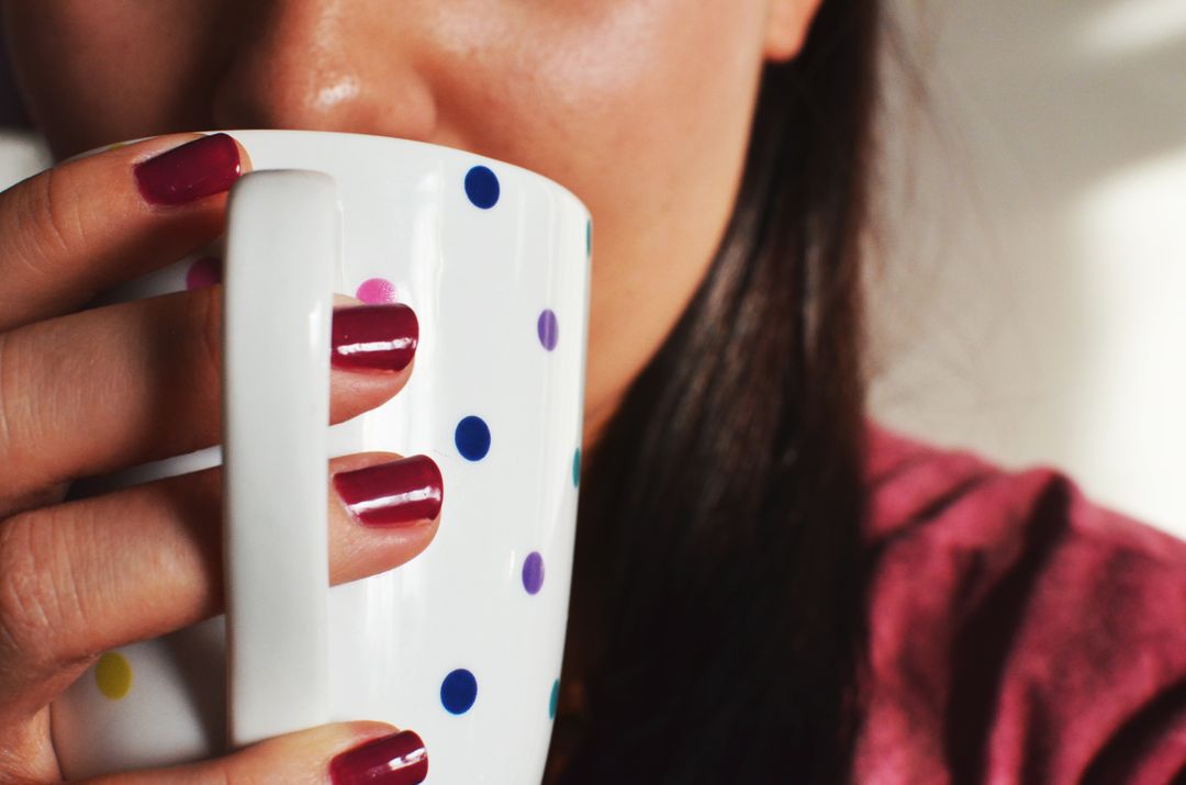Close-up of Woman Holding Polka Dot Mug with Painted Nails - Free Images, Stock Photos and Pictures on Pikwizard.com