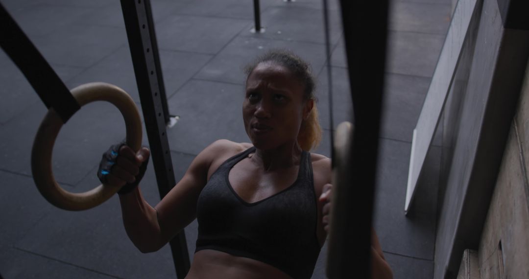 African American Woman Executing Ring Row Exercise in Gym