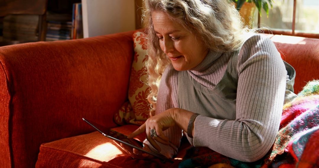 Senior Woman Relaxing on Couch with Digital Tablet - Free Images, Stock Photos and Pictures on Pikwizard.com