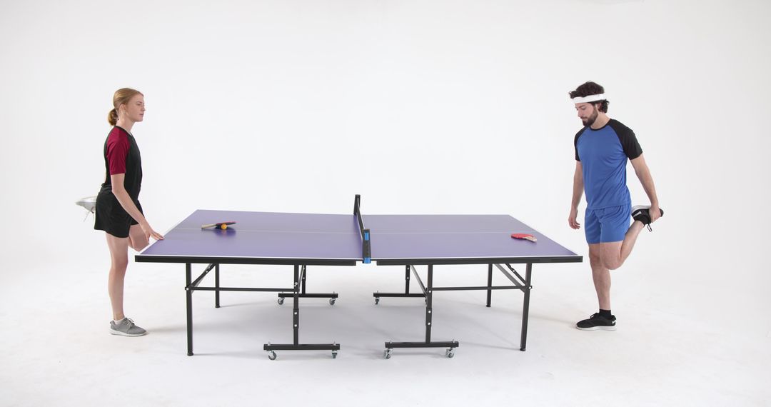 Athletic Duo Preparing for Ping Pong Game in Modern Studio