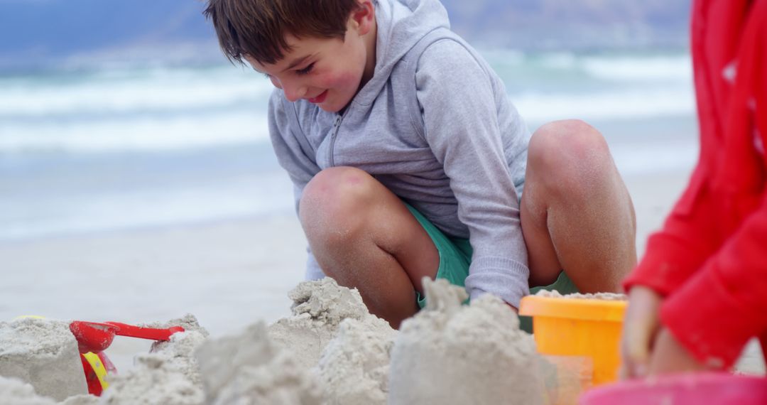 Boy Building Sandcastles on Beach with Friends - Free Images, Stock Photos and Pictures on Pikwizard.com