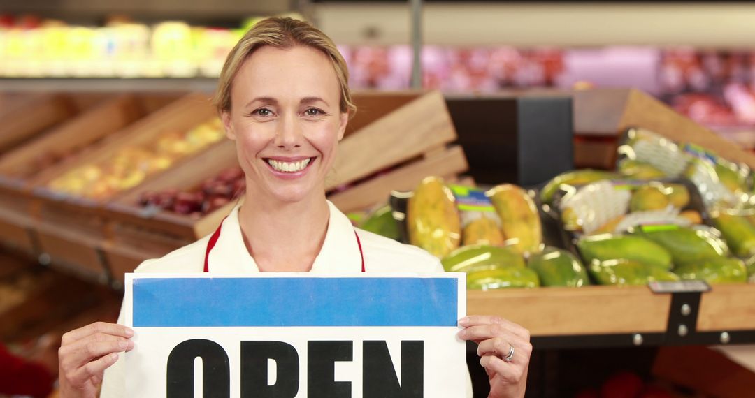 Smiling Store Employee Holding Open Sign in Grocery Store - Free Images, Stock Photos and Pictures on Pikwizard.com