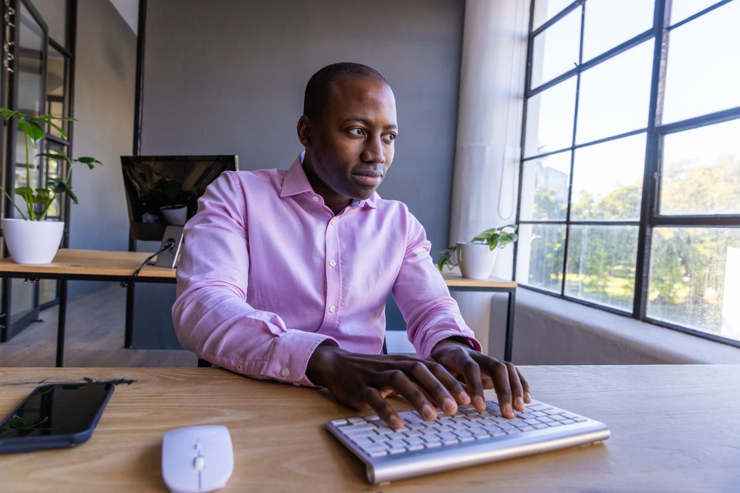 Professional Man Typing on Keyboard in Modern Office Space