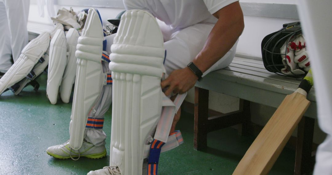 Cricketer Preparing Protective Gear in Locker Room - Free Images, Stock Photos and Pictures on Pikwizard.com