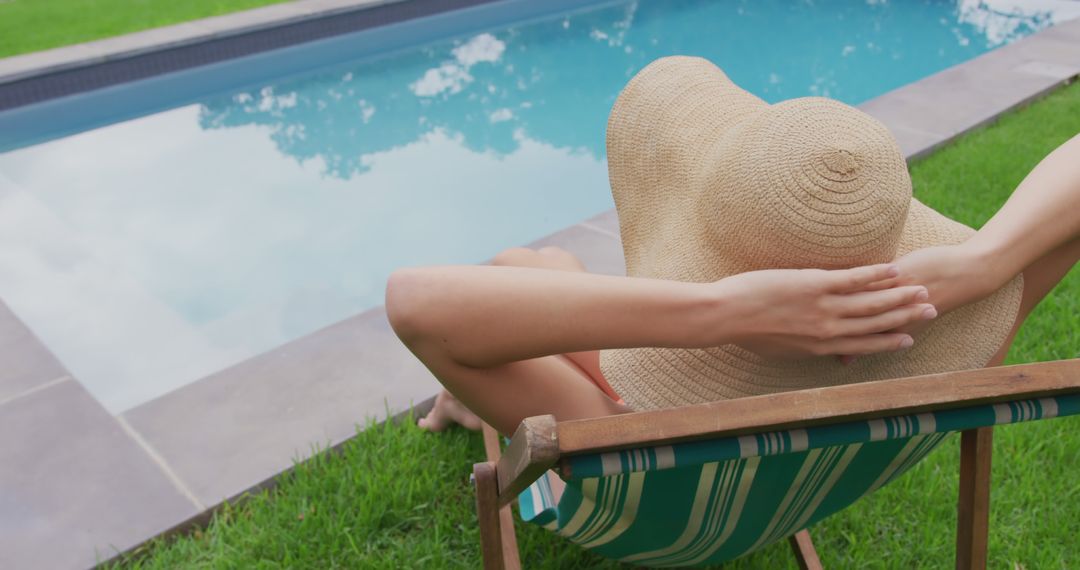 Person Relaxing by Poolside with Sunhat on a Lounge Chair - Free Images, Stock Photos and Pictures on Pikwizard.com